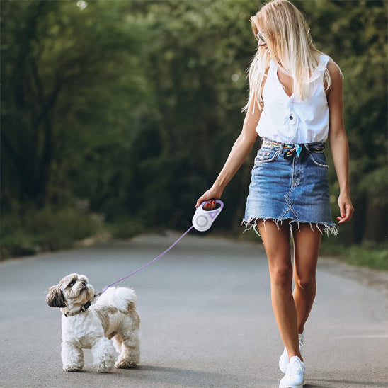 Chien avec laisse pour chien enrouleur violet avec jeune femme
